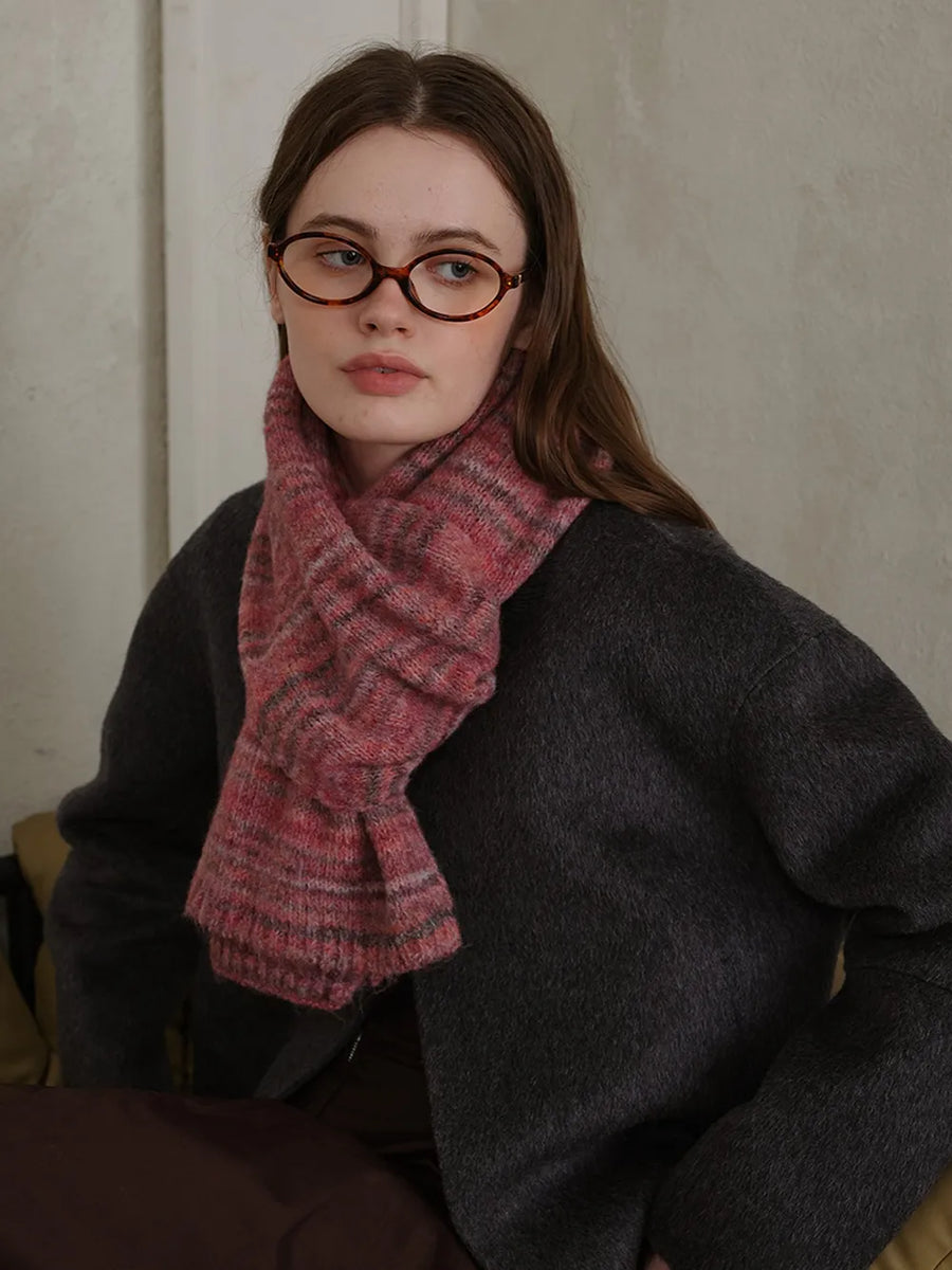 Textured mélange knit scarf in pink with grey stripes, styled with a dark grey sweater.