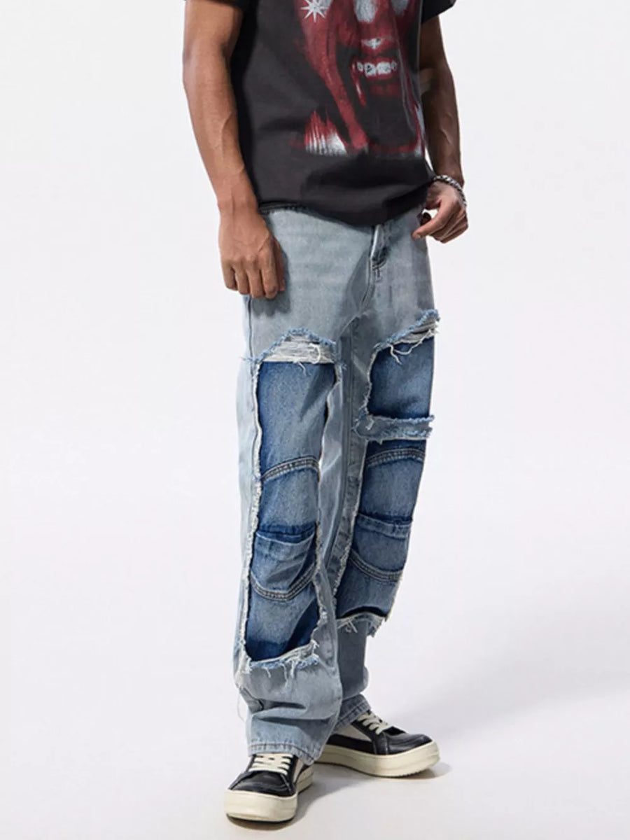 Men's light wash distressed patchwork jeans with ripped detailing and a relaxed fit.