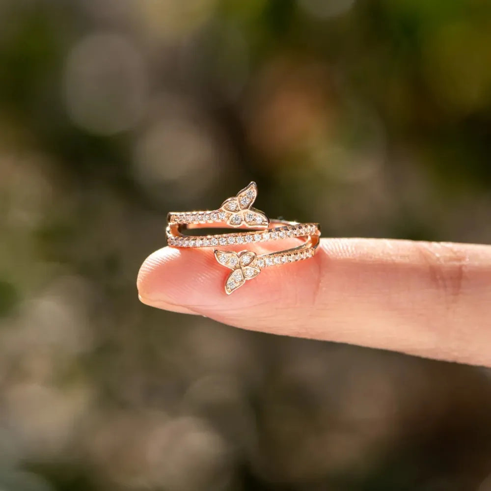 Gold bypass ring with diamond-accented butterflies and bands.
