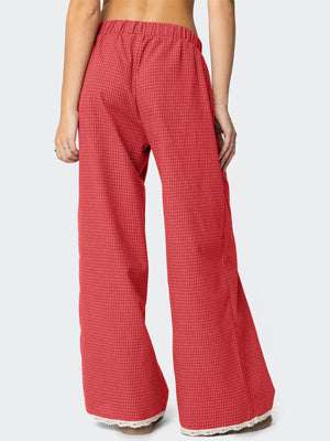 Red wide-leg pants featuring decorative button and plaid