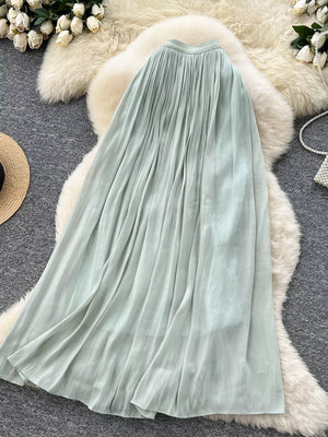 Light green pleated maxi skirt with flowing fabric and subtle vertical texture.