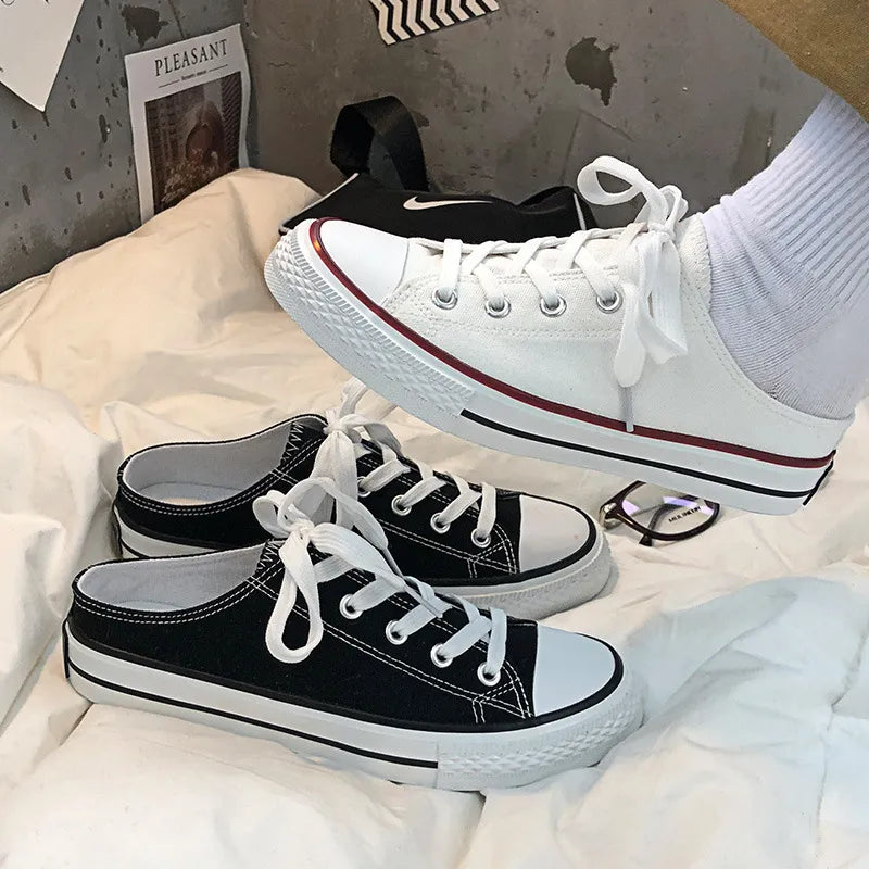 Canvas mule sneakers in black and white with contrast trim and white laces.