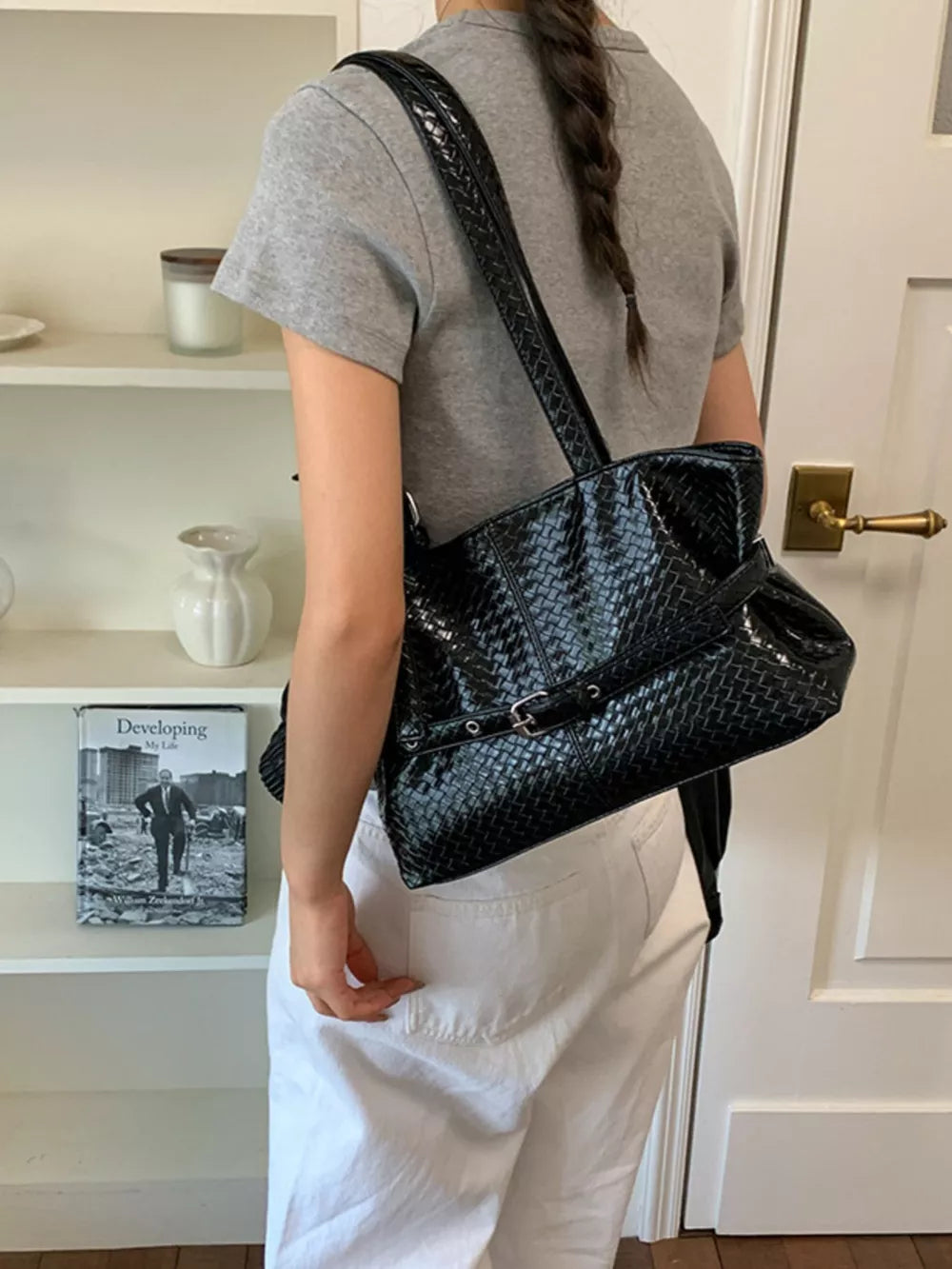 shoulder bag in black featuring woven texture and structured fit