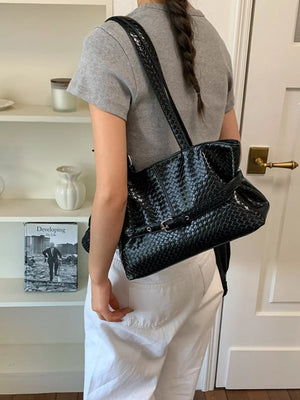shoulder bag in black featuring woven texture and structured fit