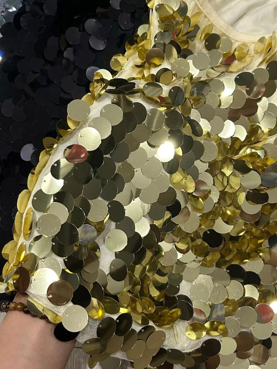 Gold sequin mini skirt with a sheer overlay and black sequin detail.