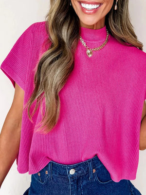 Pink ribbed knit mock neck top with short sleeves, styled with a gold necklace.