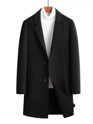 Men's black wool blend overcoat with button closure and notched lapels, styled with a white turtleneck.
