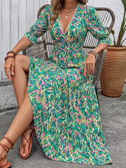 Vibrant V-neck maxi dress with abstract print, flounce sleeves, and tiered skirt.