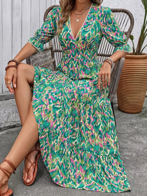 Vibrant V-neck maxi dress with abstract print, flounce sleeves, and tiered skirt.