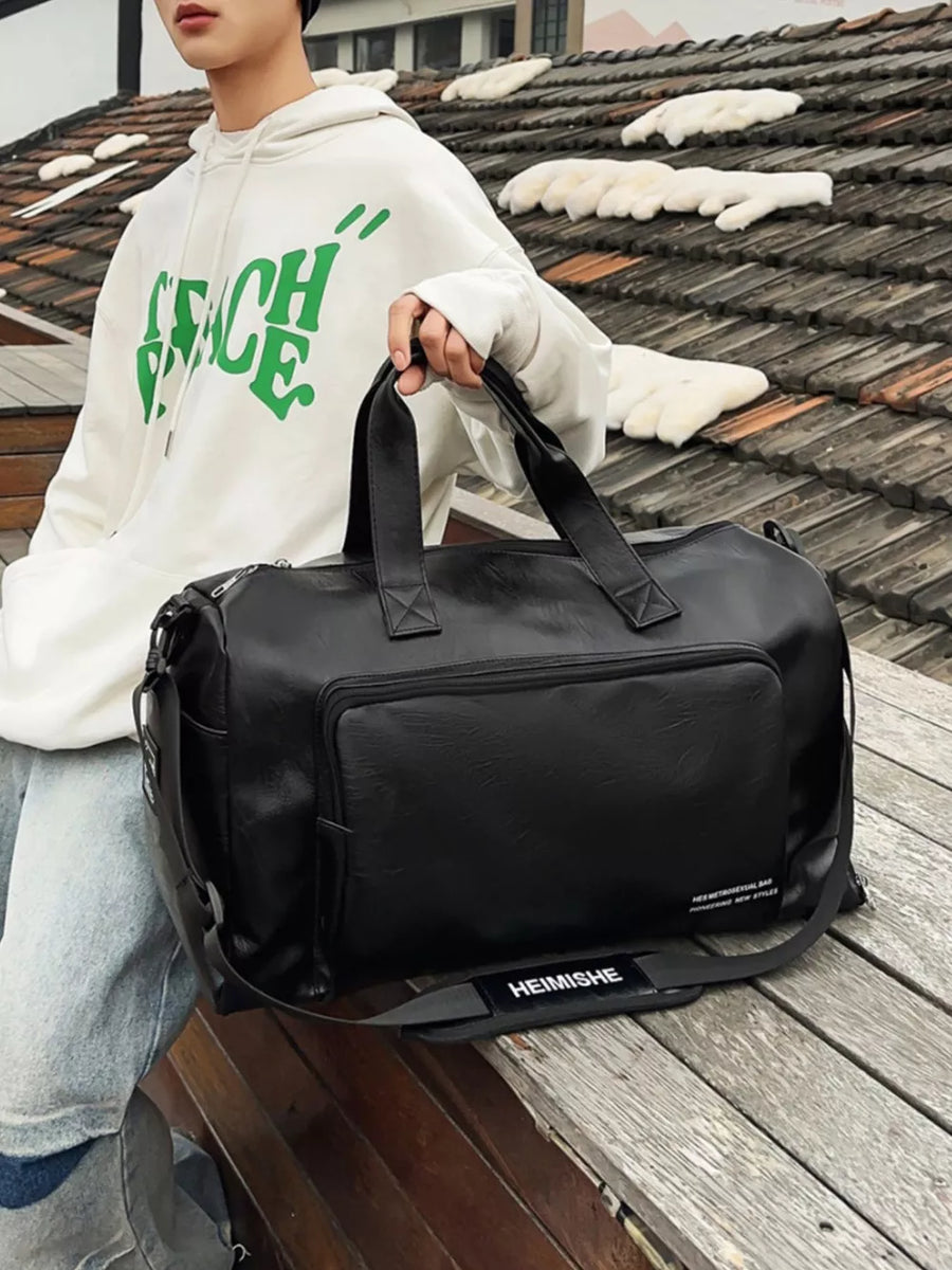 Black canvas travel bag with front pocket and detachable strap