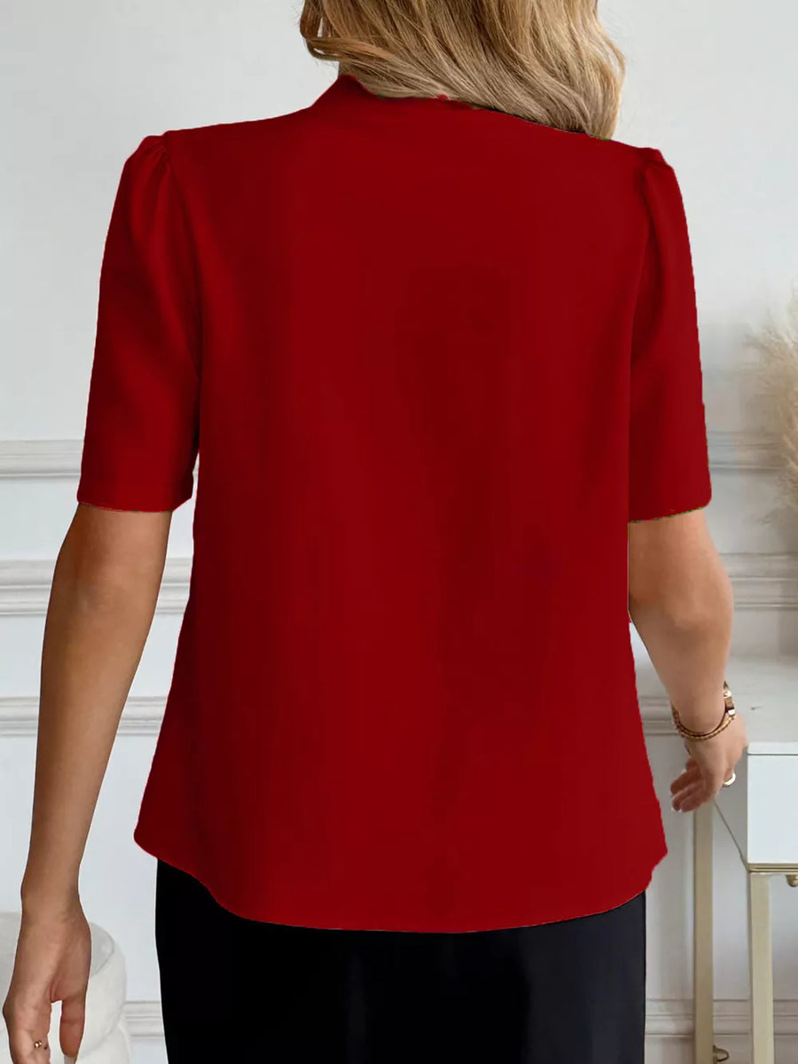 Burgundy V-neck shirt with short puff sleeves and button detail.