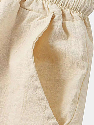 Cream linen shorts with elastic waistband and side pockets.