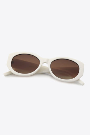 Sculpted oval frame sunglasses in beige with brown lenses and a white frame.