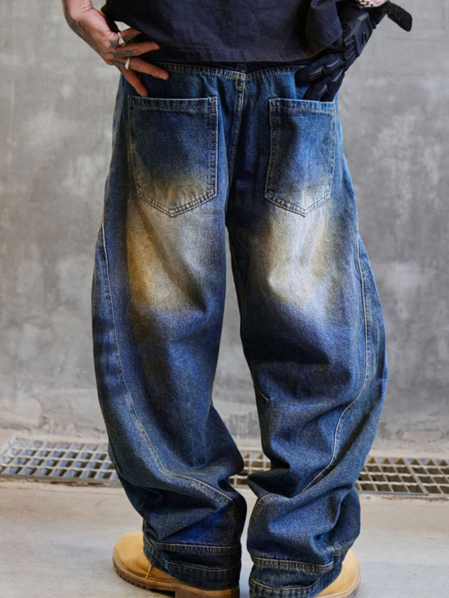 Men's blue distressed cotton wide-leg jeans with a baggy fit.