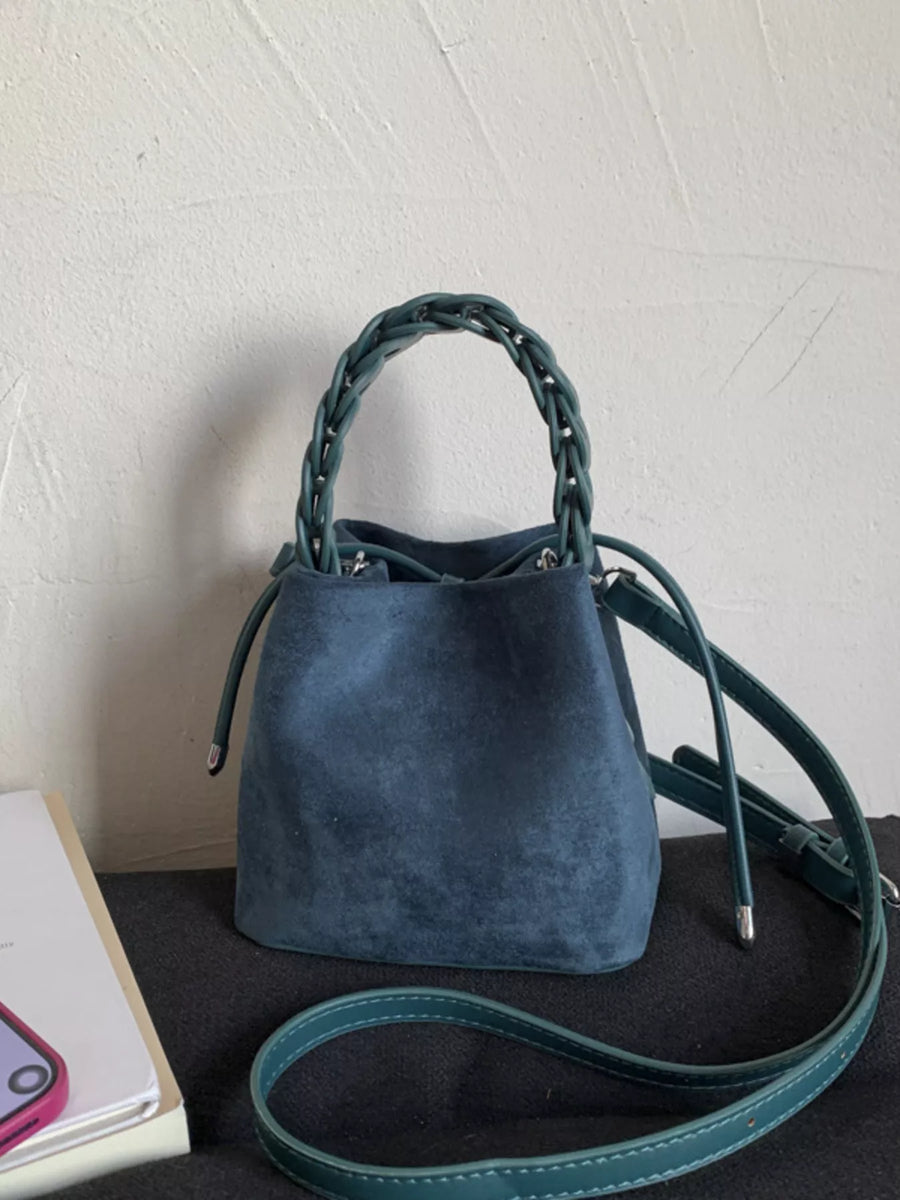 Blue suede mini crossbody bag with braided top handle and adjustable strap