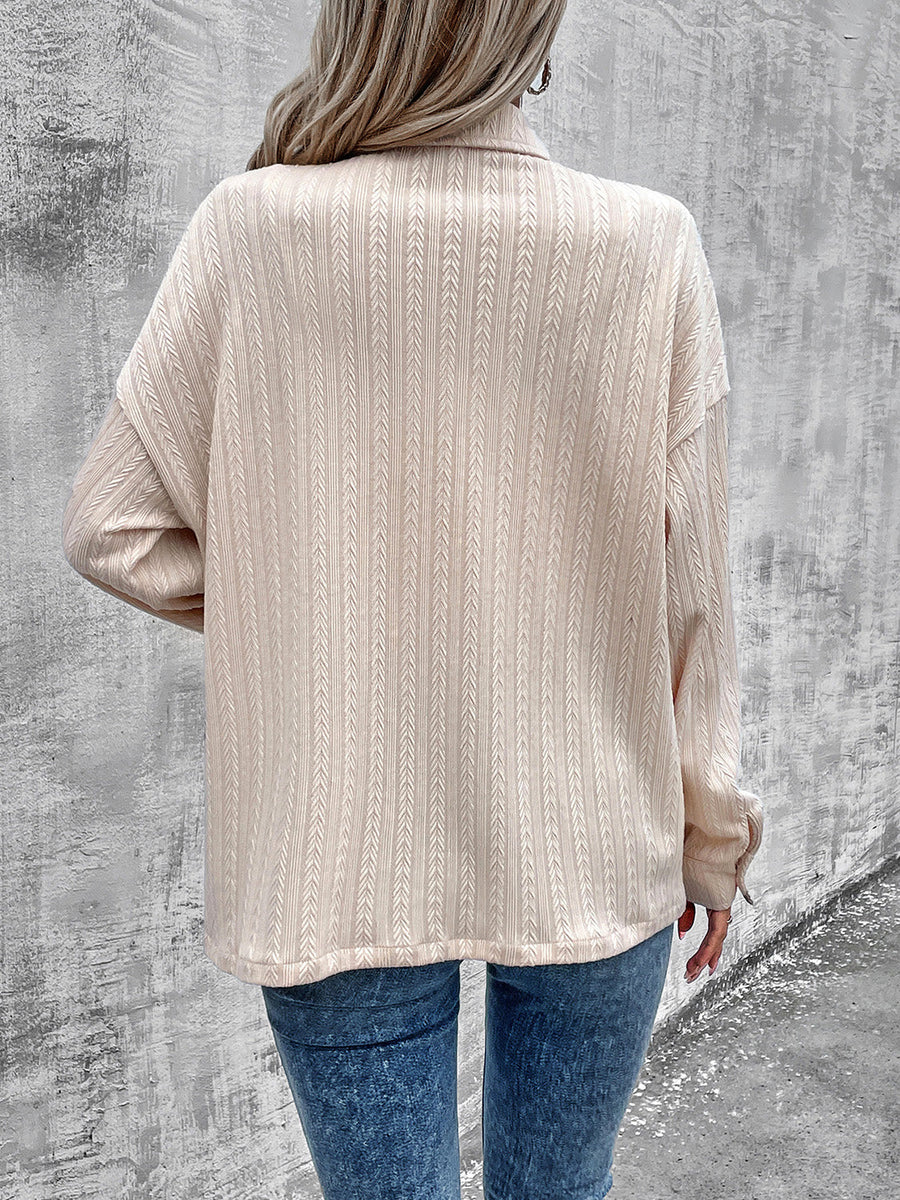 Beige textured overshirt with relaxed fit and buttoned collar, styled casually.