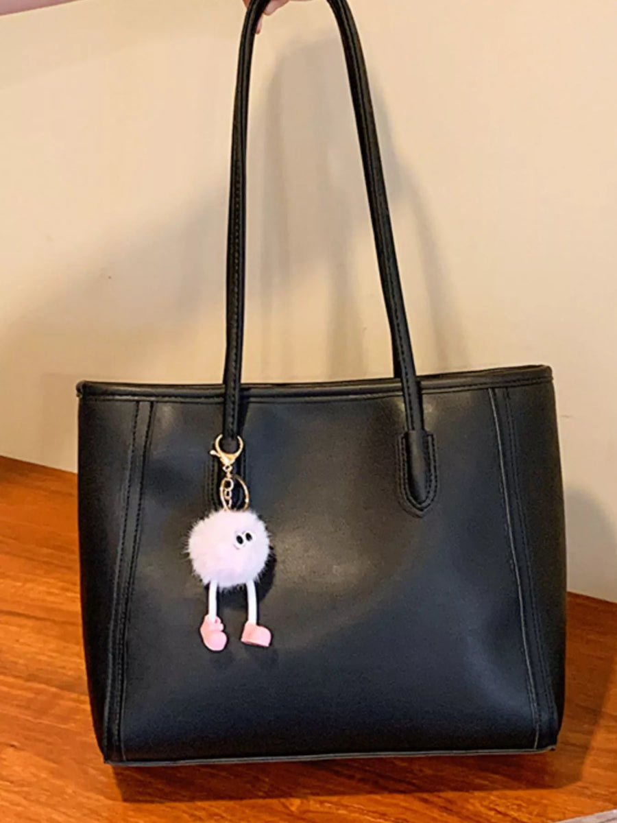 Black PU leather tote bag with a fluffy pink charm and double straps.