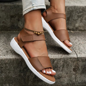 Brown adjustable platform sandals with open toe and chunky white sole.