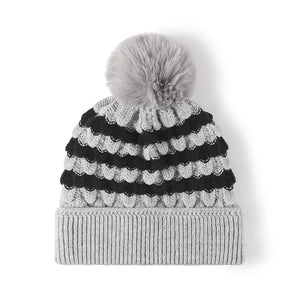Gray knit beanie with black scalloped stripes and a gray pom pom.