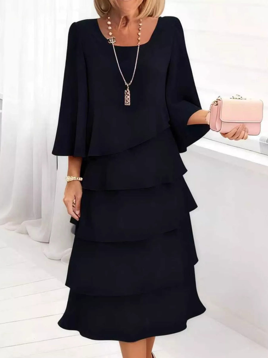 Black tiered ruffled dress with 3/4 sleeves and a square neckline.