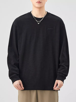 Oversized black cotton long-sleeve tee with subtle embroidered logo detail.