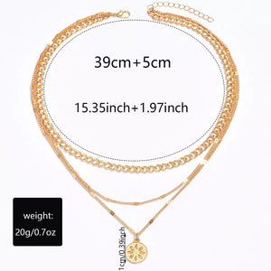 Gold layered pendant necklace with boho style chains and a floral charm.