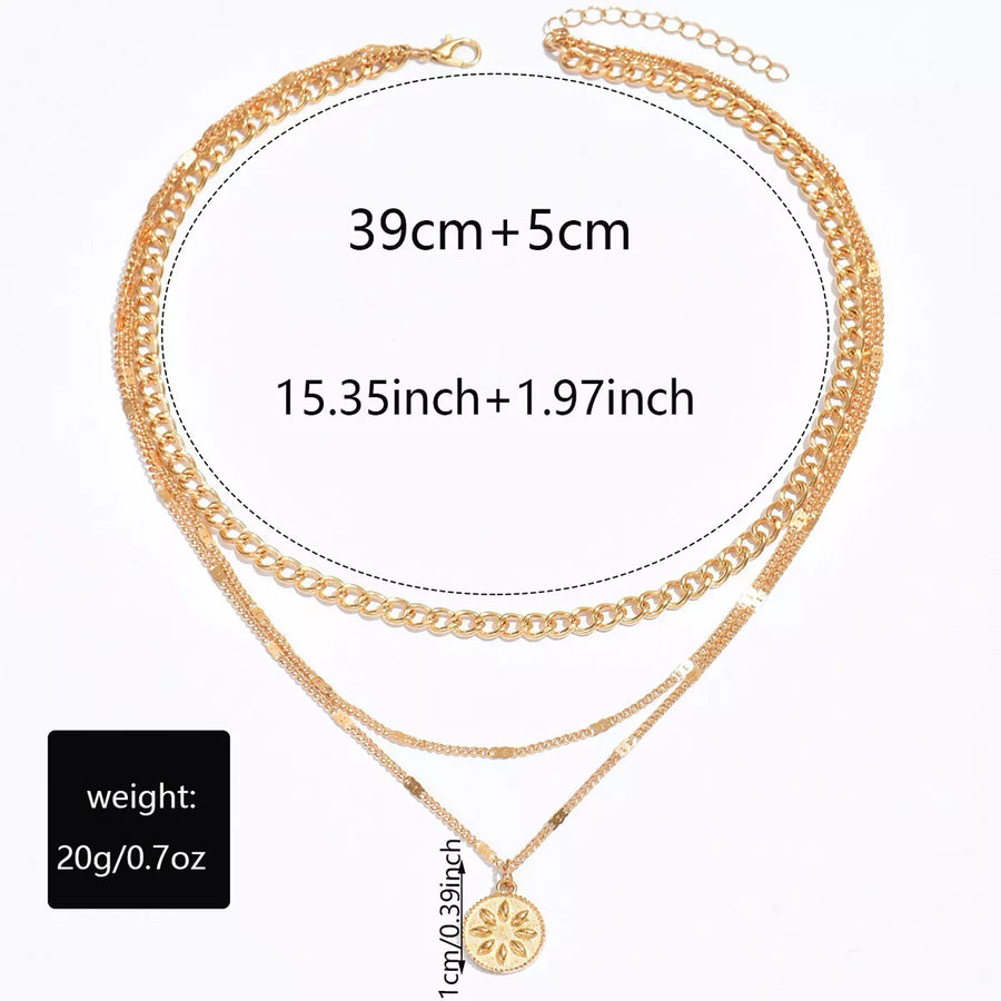 Gold layered pendant necklace with boho style chains and a floral charm.