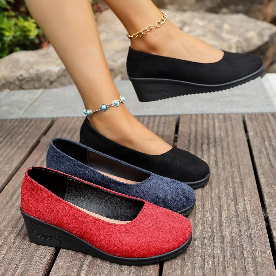 Textured round toe wedge slip-ons in red and black with a low wedge heel.