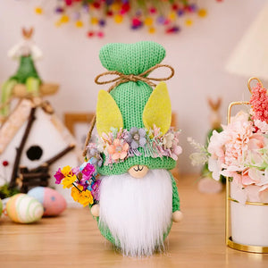 Green Easter gnome with bunny ears, floral crown, and bouquet, holding a bunch of flowers.