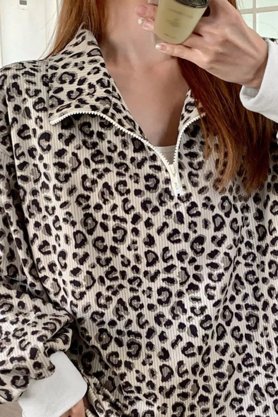 Leopard print quarter-zip sweatshirt with a collared neckline and white zipper detail.