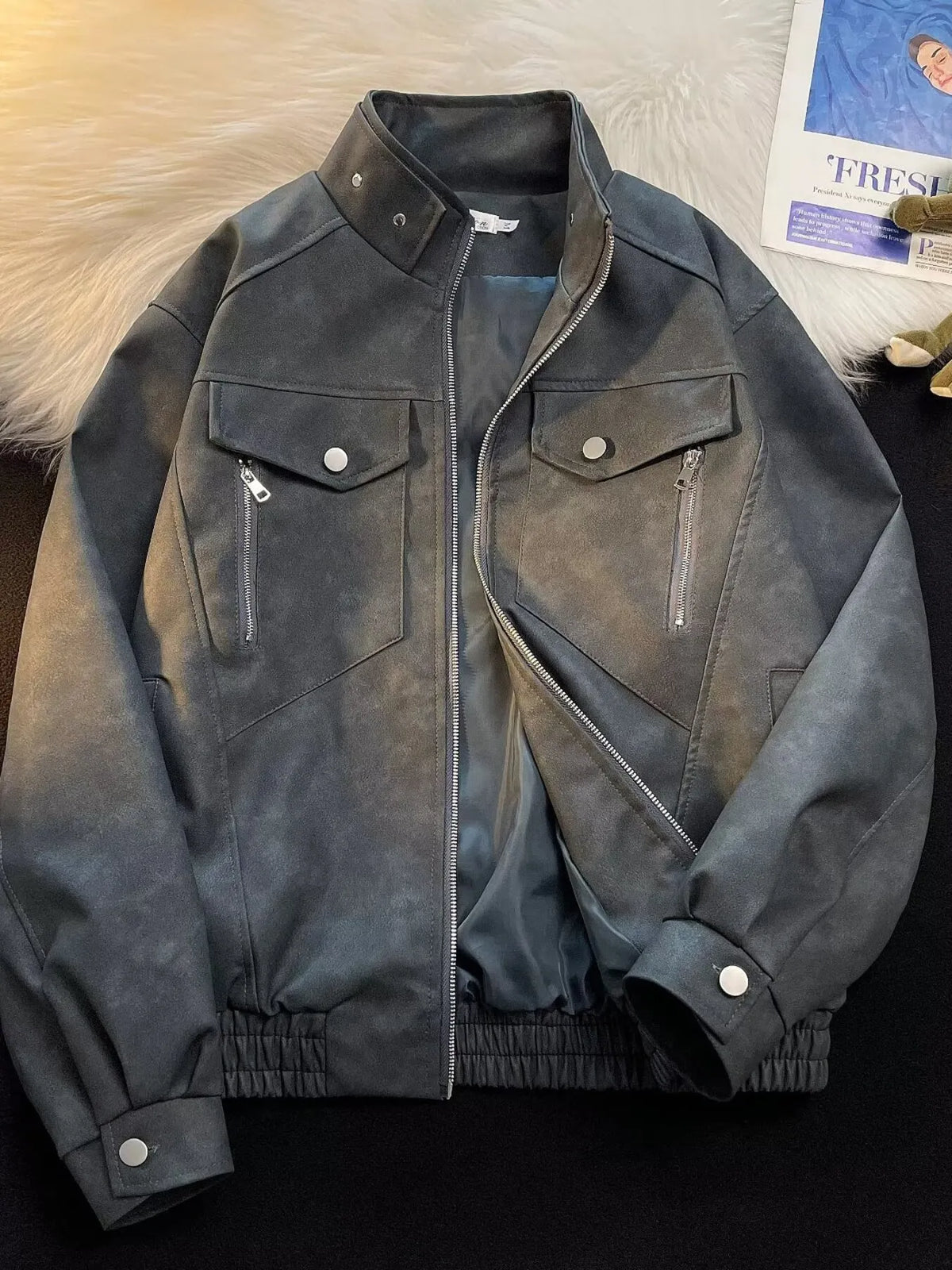 Men's gray bomber jacket with zip-up front, chest pockets, and elastic cuffs.