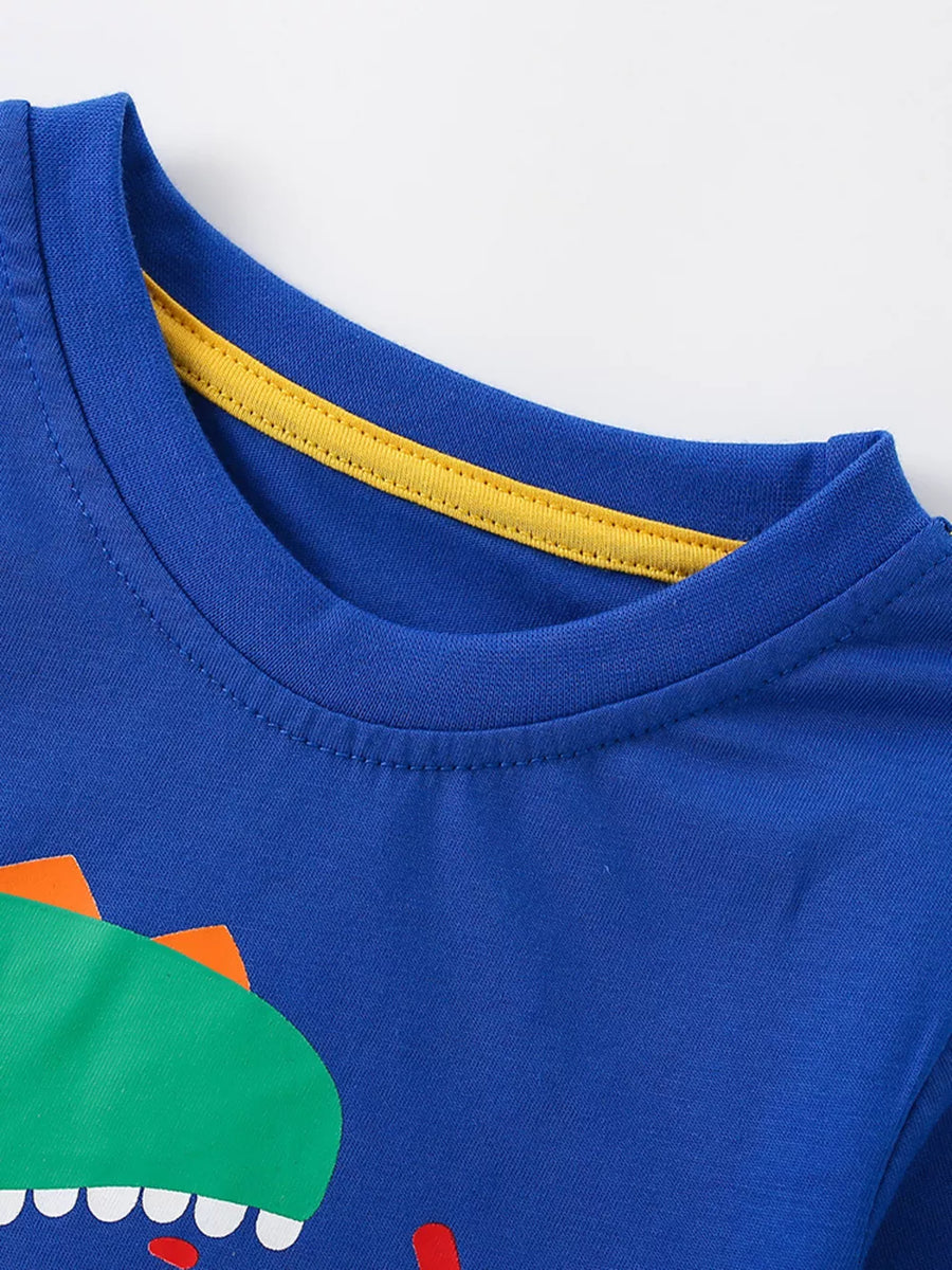 Blue cotton crew neck toddler t-shirt with a green dinosaur graphic and yellow neck trim.