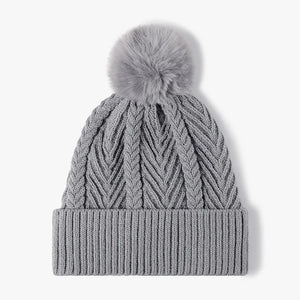Gray chevron knit beanie with a faux fur pom and ribbed cuff.