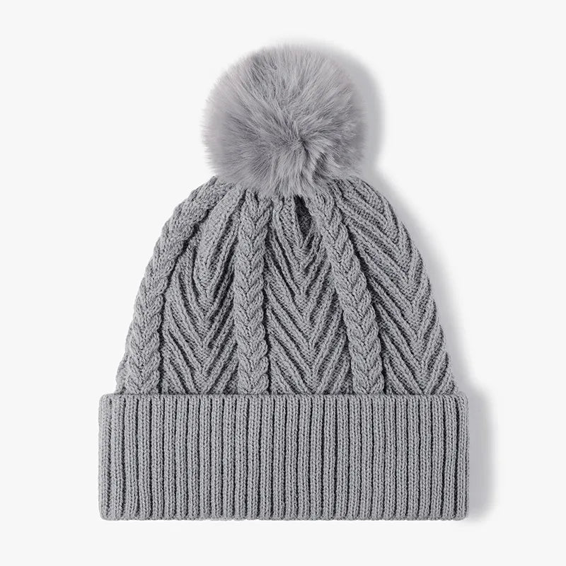 Gray chevron knit beanie with a faux fur pom and ribbed cuff.