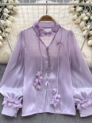 Purple sheer button-down shirt with delicate floral appliqué and tie detail.