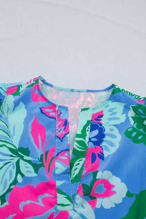Vibrant floral v-neck blouse with relaxed fit and bright pink, blue, and green print.
