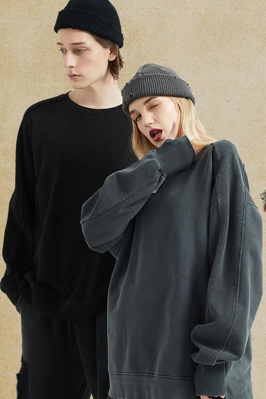 Oversized sweatshirt in dark gray with raw-edge seams and crew neck, styled casually.