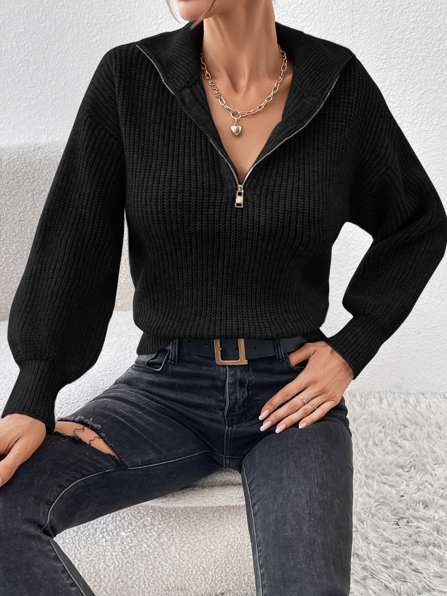 Black ribbed zip-up sweater with a high collar and balloon sleeves.