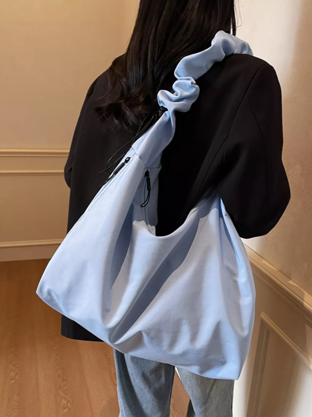 Blue ruched nylon shoulder bag with zipper detail and scrunchie strap.