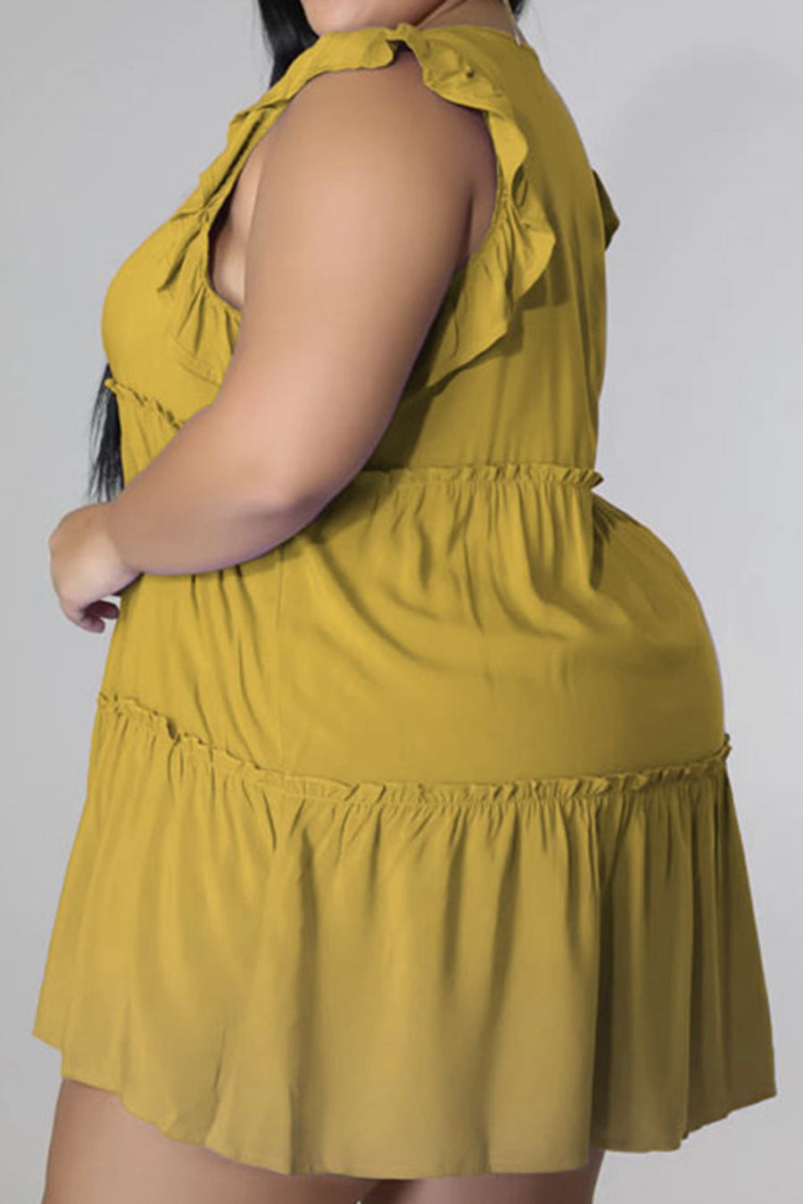 Tiered ruffle babydoll mini dress in mustard yellow with ruffled tiers and elastic waist.