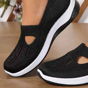 Black breathable mesh slip-on shoes with white soles and a cutout detail.