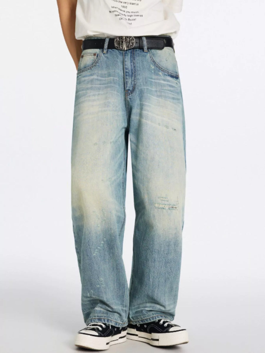 Men's relaxed wide-leg jeans in blue denim with distressed details and a faded wash.