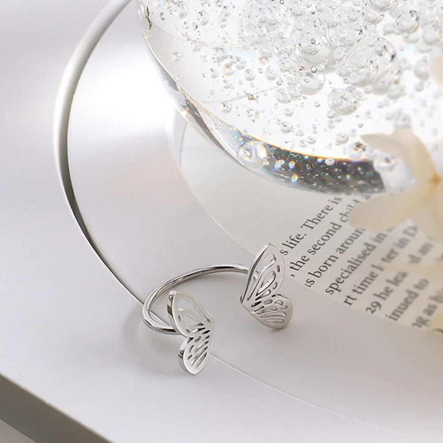 Silver butterfly wing open-ended ring with intricate cut-out details.