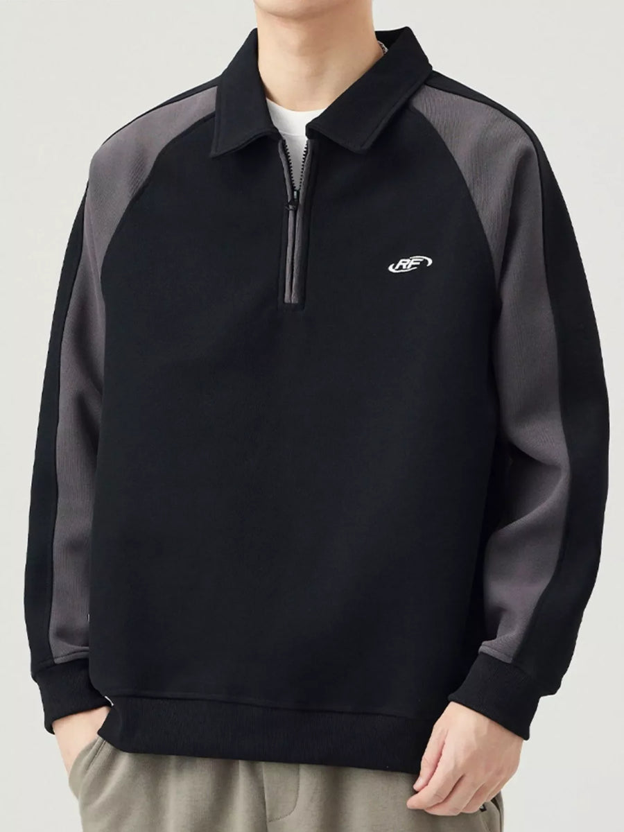 Black raglan sweatshirt with quarter zip, contrast gray sleeves, and embroidered logo.