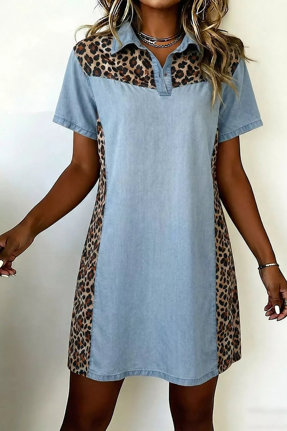 Denim shift dress with leopard print panels, short sleeves, and collar.