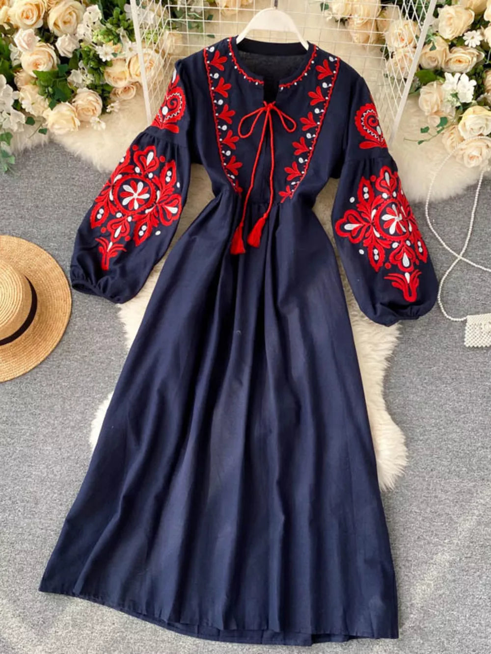 Navy blue maxi dress with red embroidery, balloon sleeves, and tie neck