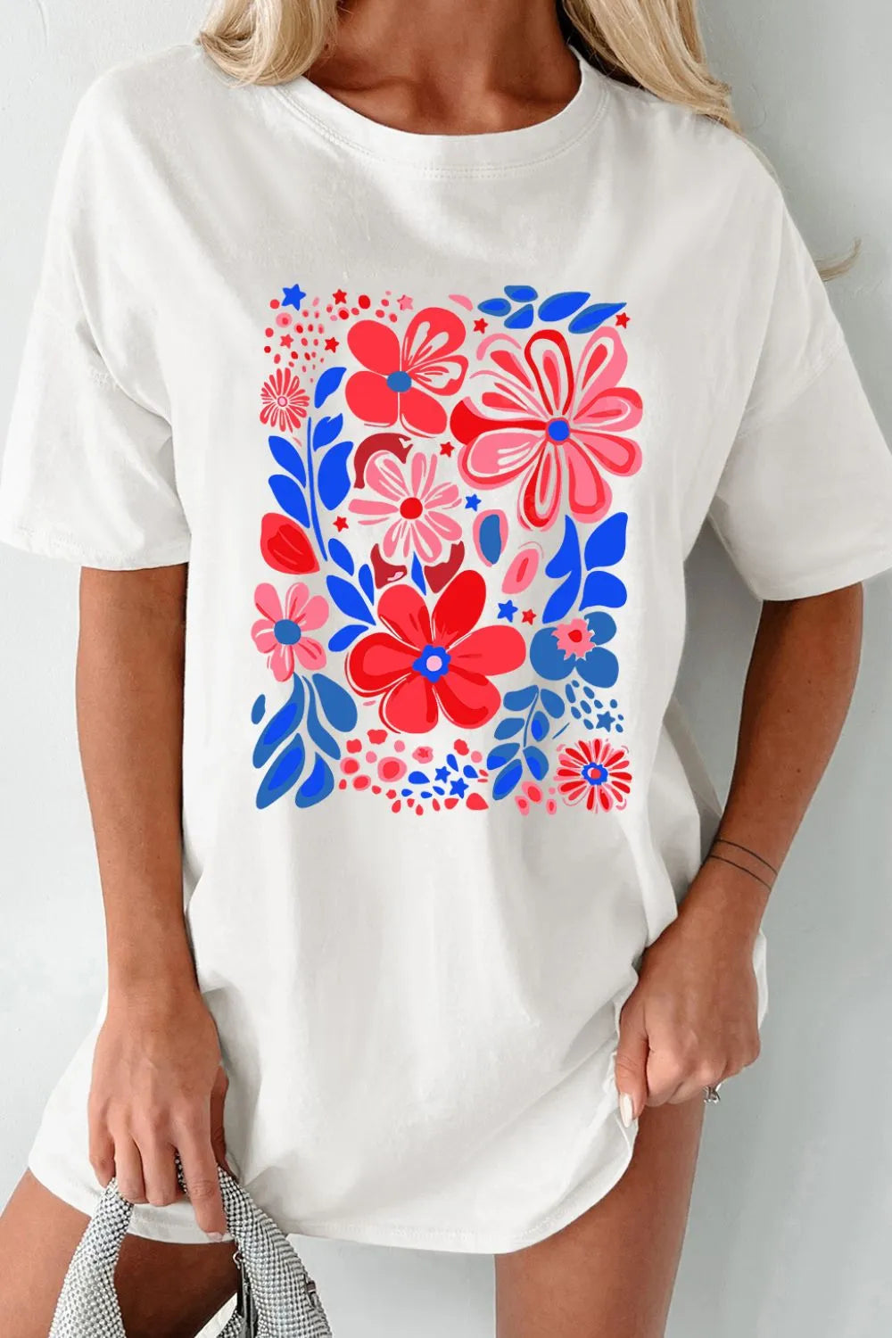 Oversized white graphic tee dress with a colorful floral print and short sleeves.