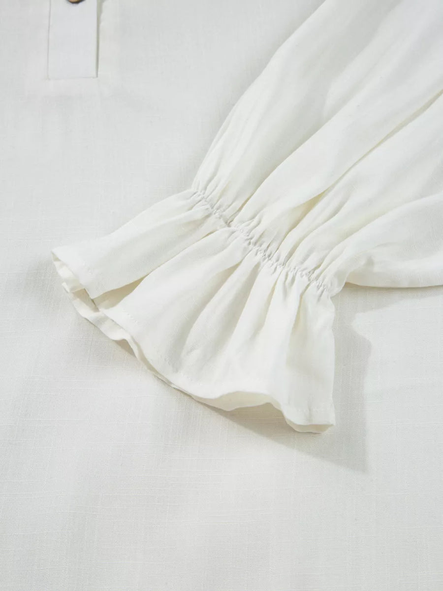White linen shirt with ruffled cuffs and a button detail