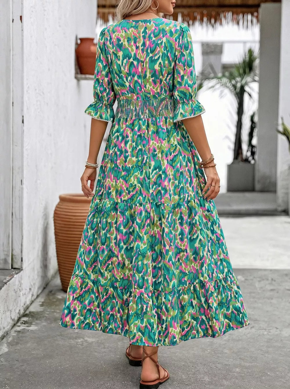 Vibrant abstract print maxi dress with V-neck, flounce sleeves, smocked waist, and tiered skirt.