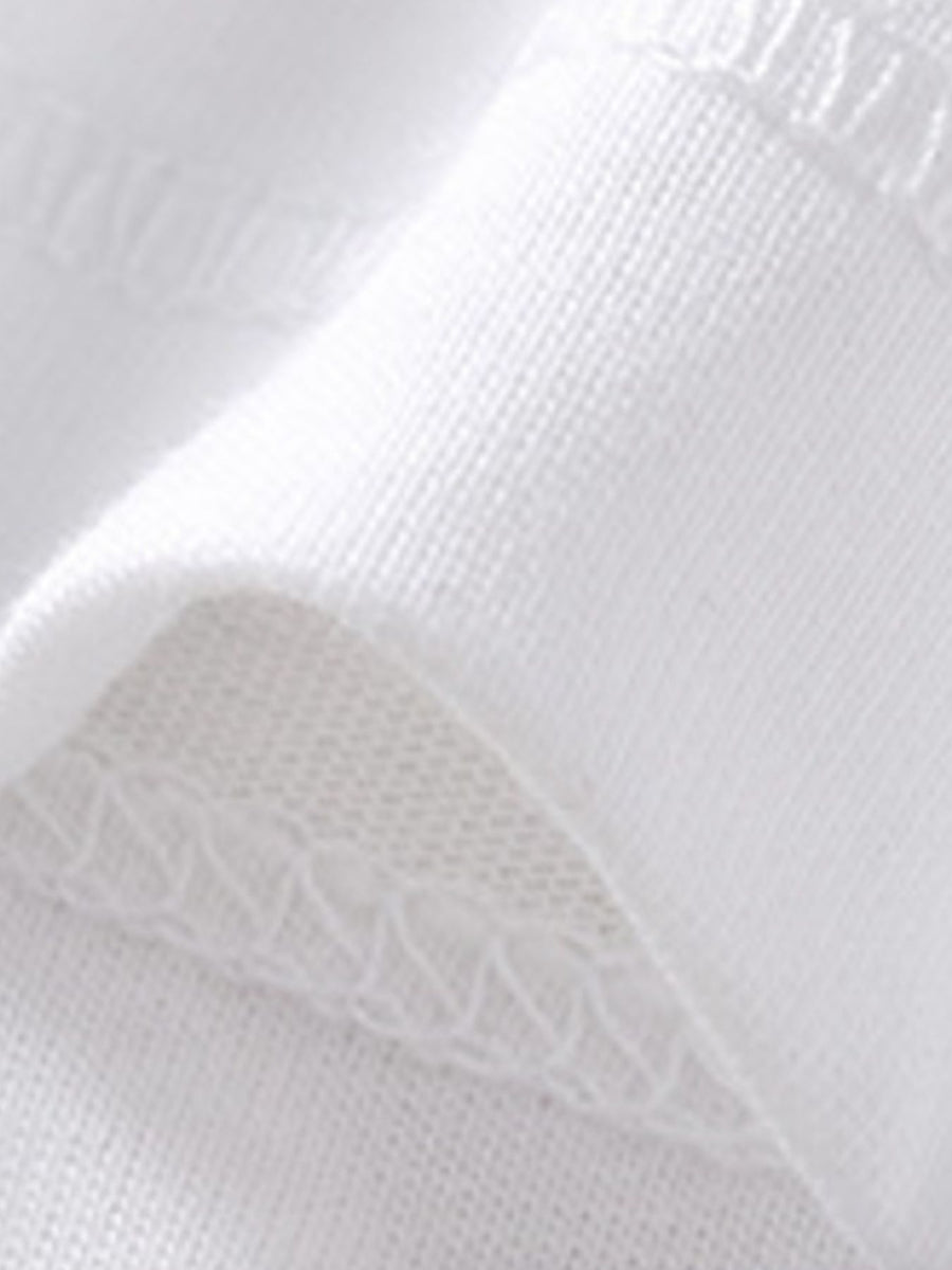 White cotton polo shirt detail showing fabric texture and stitching.